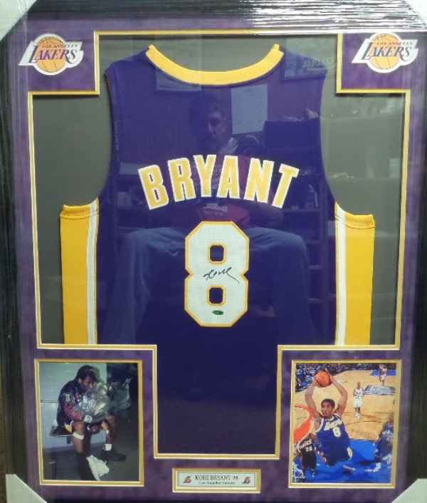 This spectacular display is 3x4 FEET in size, and comes custom triple matted in gold purple and white Lakers team colors. It has 4 custom cutouts, but the main piece is an INPerson Authentics hologrammed game jersey from Kobe. It is signed in bold black sharpie, has Lee's added ok for certainty, and shows off well from a football field away!  Great investment chance, and we'll guess value at $12,000 after PRO framing.