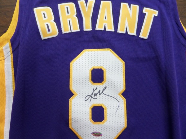This mint road LA purple style is a beauty, comes trimmed in gold and white team colors, and has sewn on everything as well as name on back. It comes back #8 signed by the HOF Legend in bold black sharpie, grades a bold clear 10 all over, and even has the sought after INPersonAuthentics lifetime hologram and cert included. Wow!  