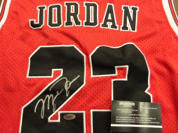 This mint tagged 1990's style is a road red, trimmed in white and black Bulls team colors, has sewn on everything as well as name on back, and comes back #23 signed by the best ever in boldsilver paint pen. It grades a Lee approved 15, shows off well from 20+ feet away, and has the sought after InPerson Authentics lifetime COA and added hologram. Wow!