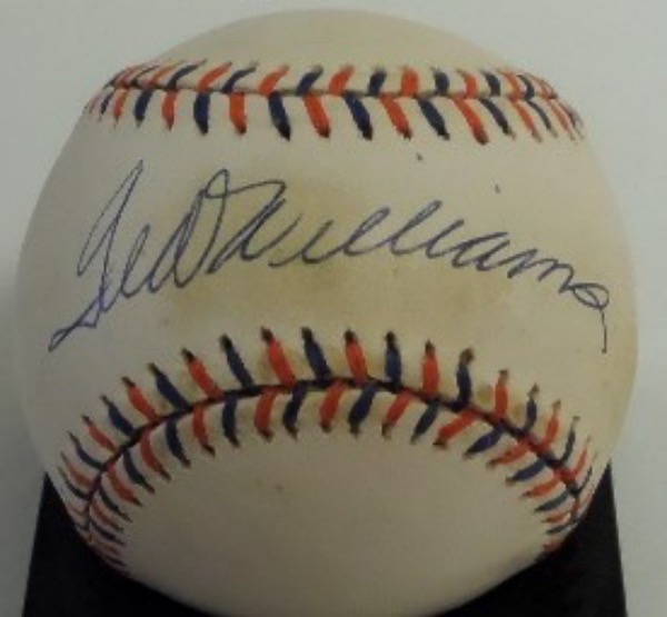 This blue and orange-laced Official 1992 All Star Game baseball from Rawlings is cubed in VG+ condition.  It is hand-signed right on the sweet spot by 2 time Triple Crown winner and HOF Red Sox outfielder Ted Williams, grading a legible 8.5.  A great looking baseball, valued into the mid/high hundreds!