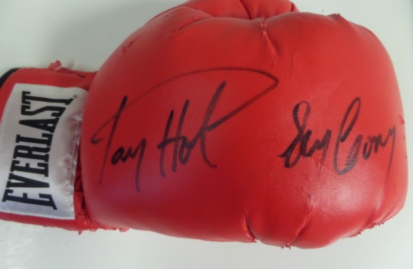 Their 1982 superfight was, at the time, the highest grossing match in the history of boxing!  Here, we have a well-worn red Everlast boxing glove, in F/G condition, hand-signed in black sharpie by BOTH participants in said fight.  Included are Larry Holmes and Gerry Cooney, with each signature grading a legible 8, and retail is high hundreds on this sweet science collector's jewel!!!